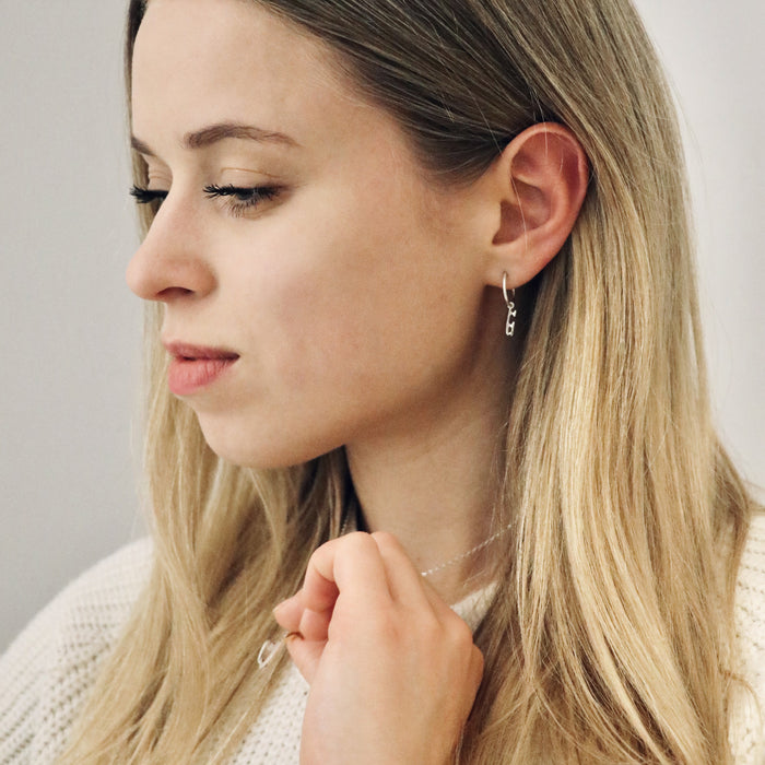 lady wearing silver ice skating hoop earrings