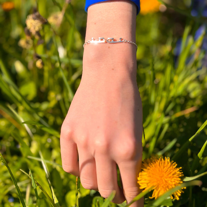 hand holding a flower and wearing a double silver ice skate blade bracelet