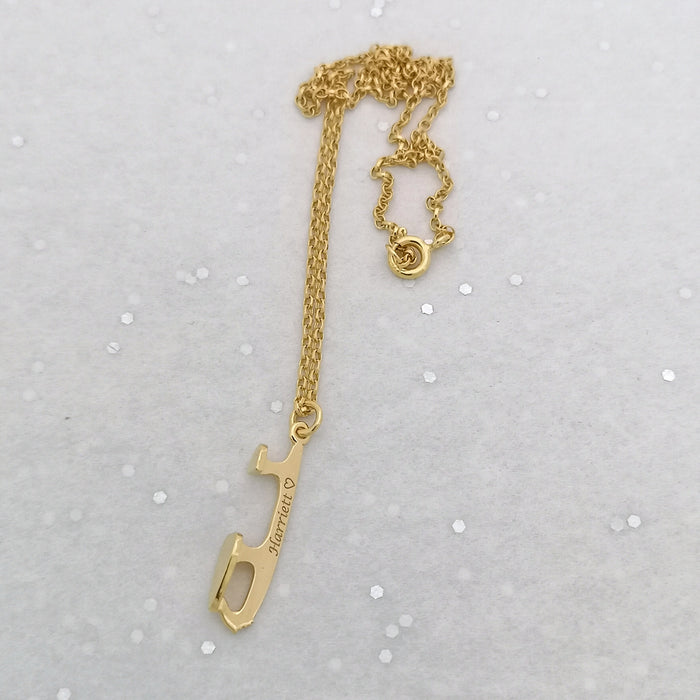 personalised gold ice skating necklace on a sparkly background