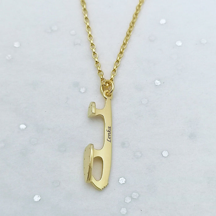 personalised gold ice skating necklace with the name Lenka on a pale off-white sparkly background