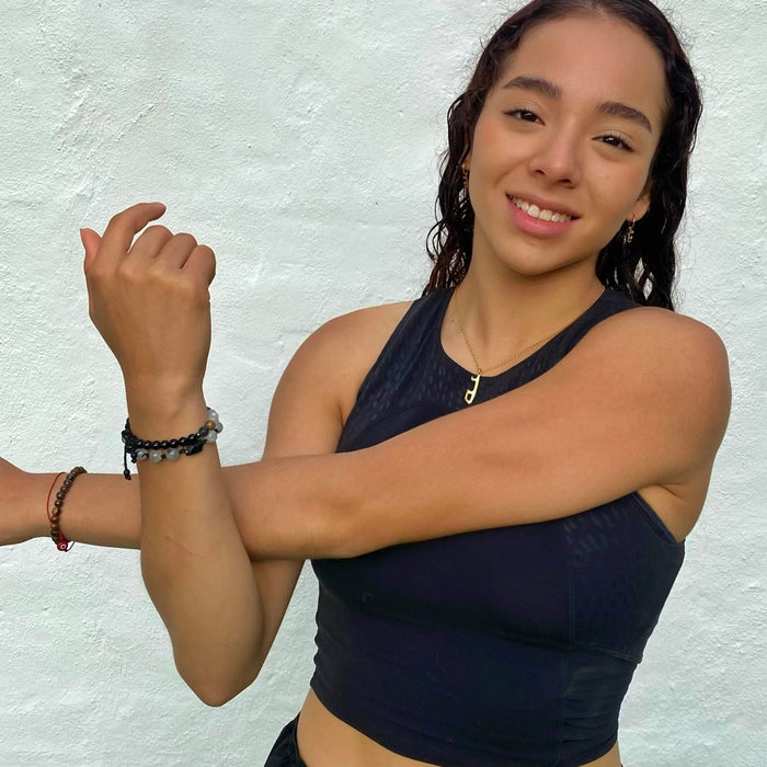female skater in a black top wearing apersonalised gold ice skating necklace