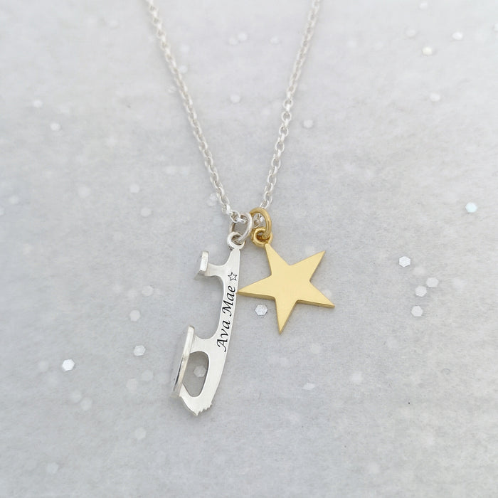 personalised silver necklace with a silver ice skate blade and a star charm on a grey background