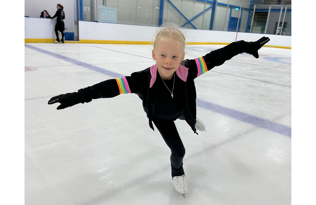 young female ice skater on an ice rink on one foot