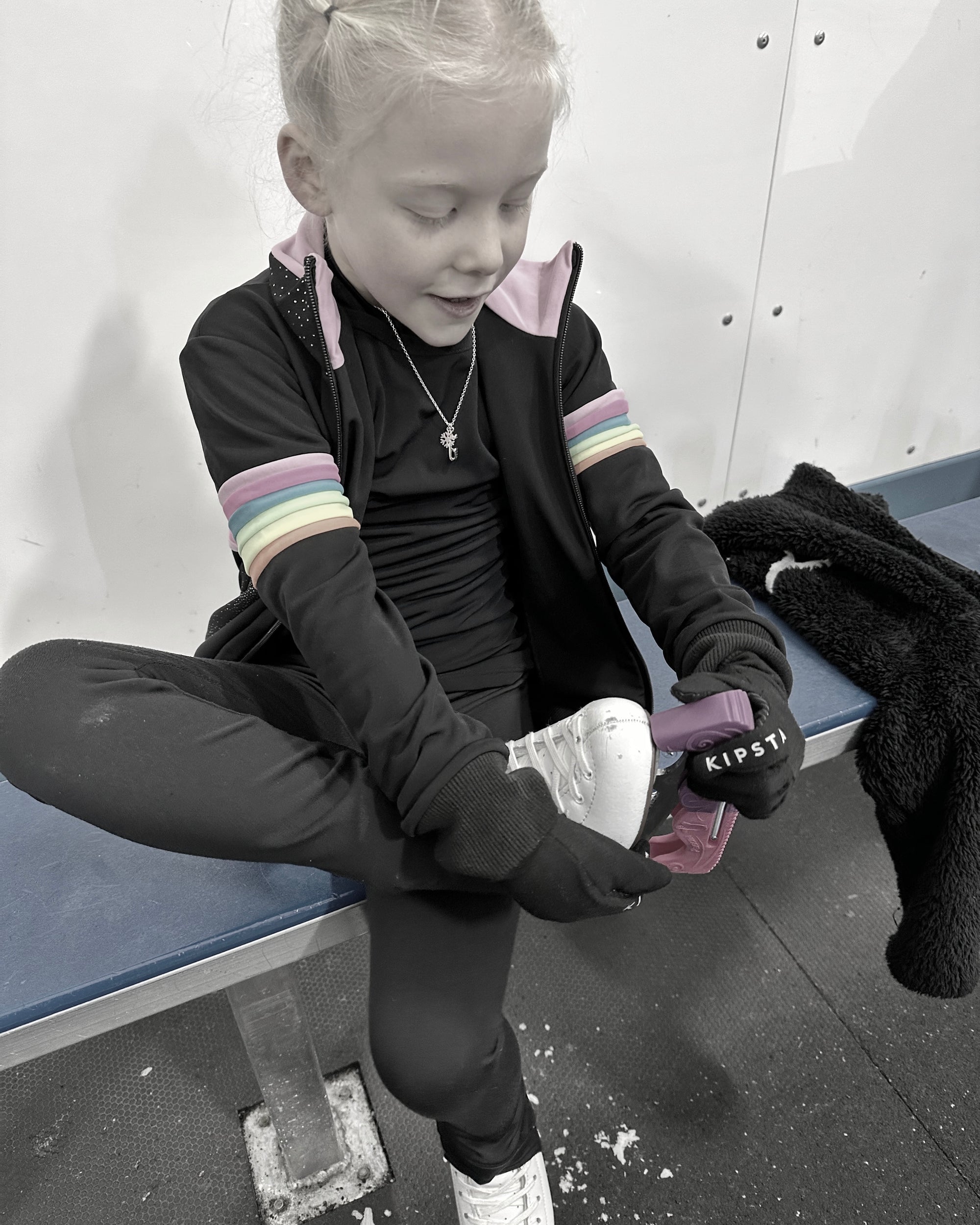 young figure skater taking off her boots after a training session