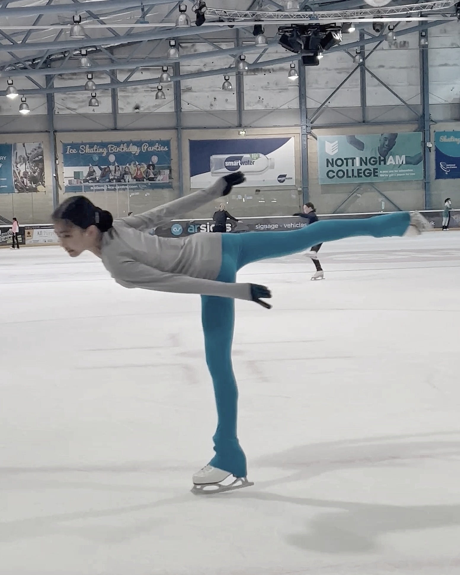 snapshot of a figure skater performing a camel spin on the ice rink