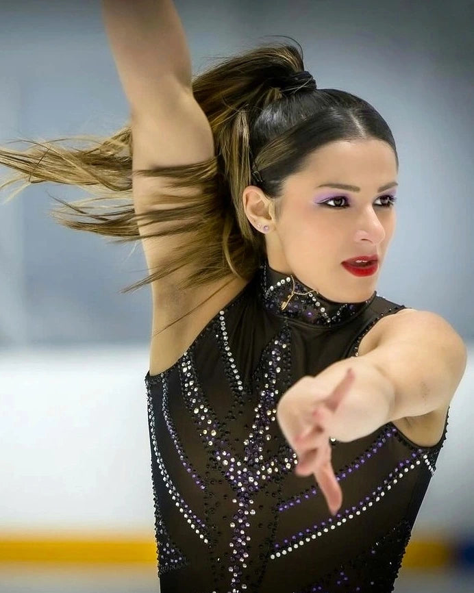 Dramatic close-up of figure skater performing on the ice with flowing hair and determined expression.