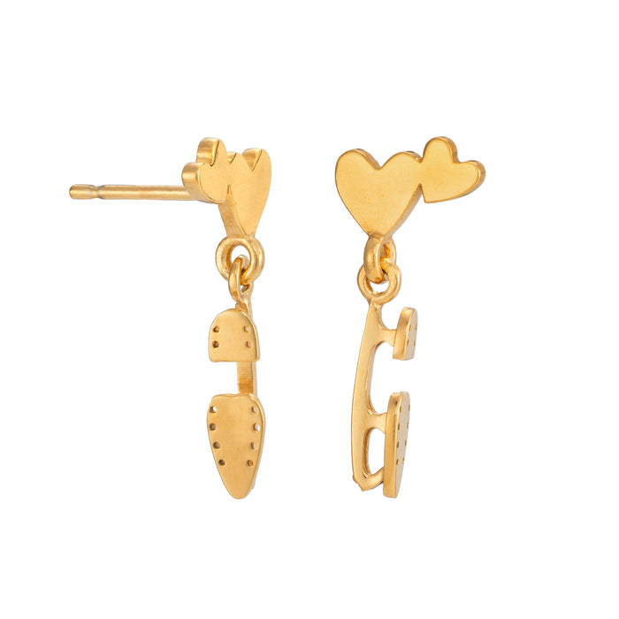 gold ice skate blade and heart stud earrings on a white background