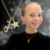 Young girl wearing a gold necklace with a star pendant and 'Believe in Yourself' message, against a blurred background.
