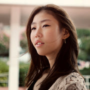portrait shot of gold ice skating stud hoop earrings on a female ice skater