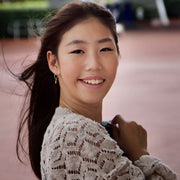 image of a girl wearing gold ice skating stud hoops featuring tiny ice skate blades