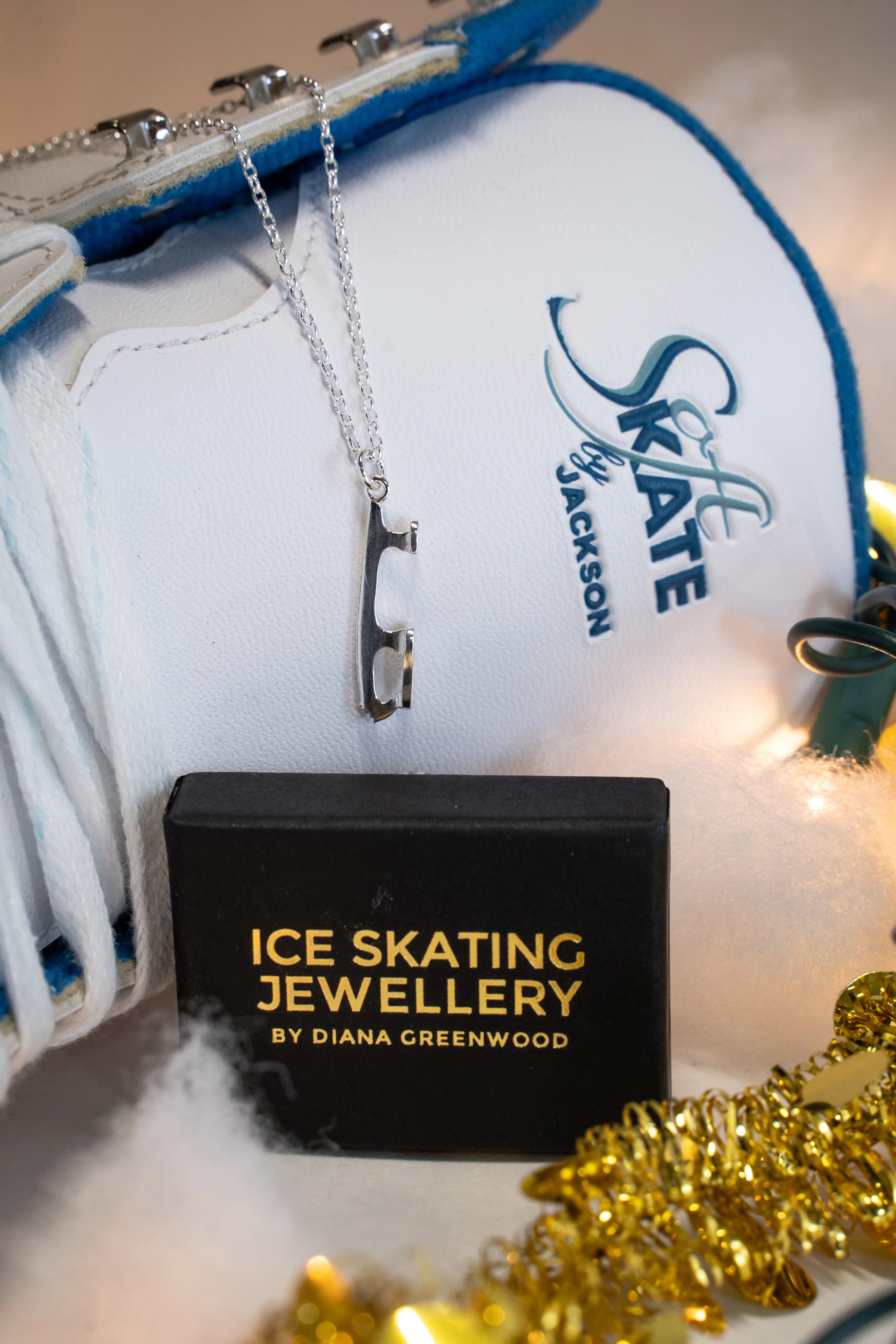 close-up image of a figure skating boot and a silver ice skating necklace