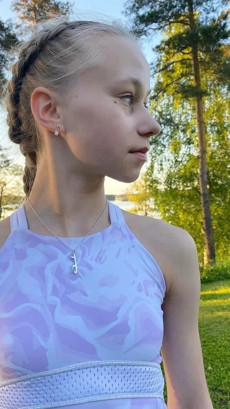 figure skater janna jyrkinen wearing a lilac top and a personalised silver ice skating necklace