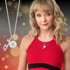 Woman wearing a red outfit with a necklace, against a blurred background