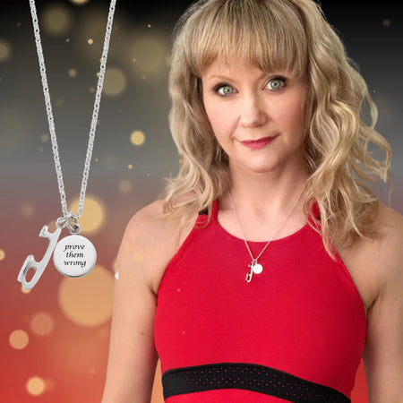 Woman wearing a red outfit with a necklace, against a blurred background