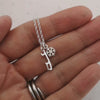 video of a hand holding a silver necklace with a snowflake and a tiny ice skate blade charm