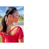 video of a figure skater spinning on ice and a girl in a red top wearing ice skating earrings
