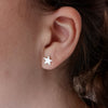 Close up of Silver star stud earrings being worn