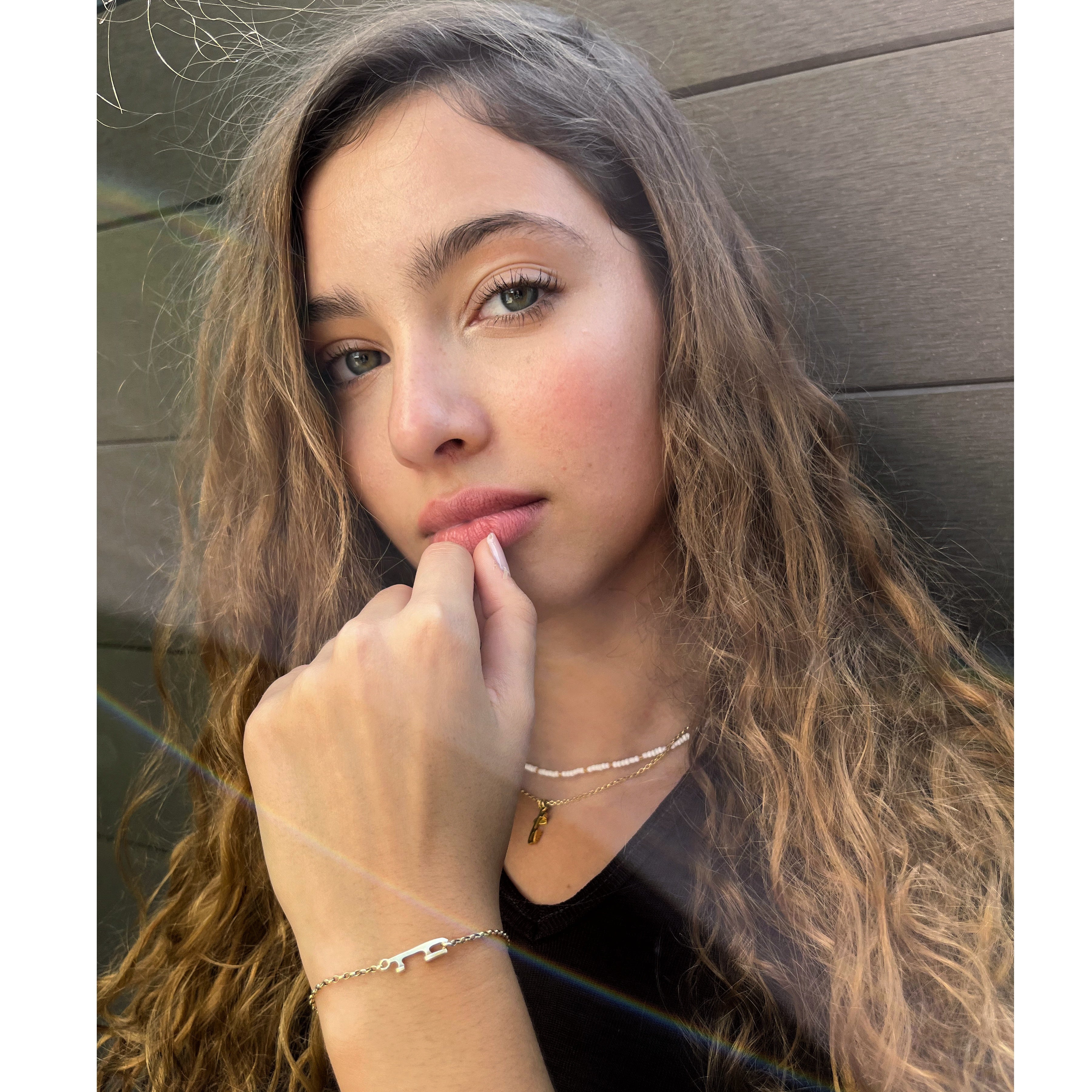 figure skater wearing a gold ice skating blade necklace and a gold bracelet featuring an ice skate blade